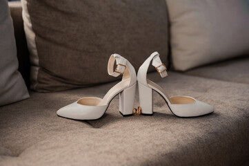 Elegant White Heeled Shoes on a Plush Sofa