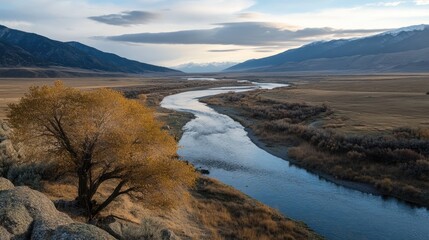 Scenic River Flowing Through a Valley Surrounded by Majestic Mountains and Autumn Foliage