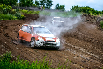 Rally car in the cloud of smoke on a dirty road  