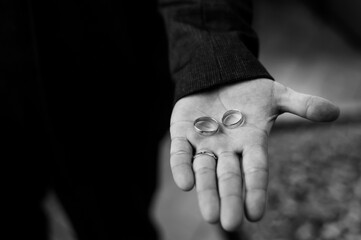 Elegant Black and White Photograph of Wedding Rings Held in a Hand