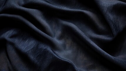 Fototapeta premium Fabric texture with dark tones showcasing elegant draping and soft folds suitable for fashion and textile background designs.
