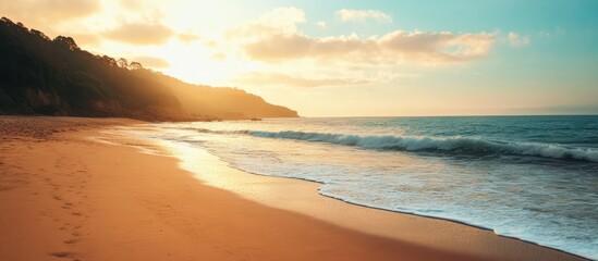Serene summer beach landscape at sunset with gentle waves and golden sand reflecting warm sunlight