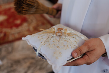 Elegant Wedding Rings Presented on Decorated Cloth During Ceremony