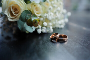 Elegant Wedding Rings Nestled Beside a Rustic Bouquet