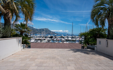 Saint-Jean-Cap-Ferrat, France - May 03, 2024: Marina Viewing Terrace with Palm Trees and Luxury Yacht Harbor View