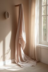 Draped blush pink fabric hanging in a sunlit room.