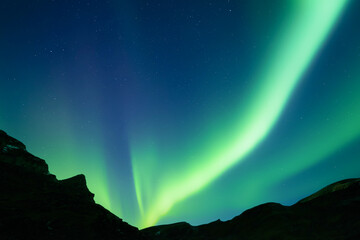 Night sky with green Aurora borealis Northern lights in winter mountains. Sky with polar lights and...