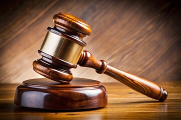 Close up of a judicial gavel with a golden band, representing law and courtroom decisions.