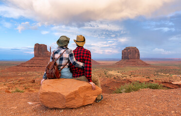 Young couple enjoying sunset view of Monument Valley National Park.