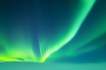Aurora borealis in night winter sky. Sky with polar lights and stars. Waves of green Northern lights in Earth atmosphere