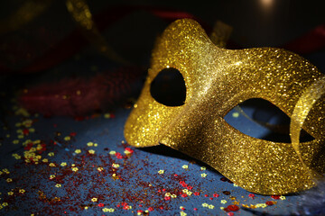Beautiful carnival mask and confetti on dark background, closeup