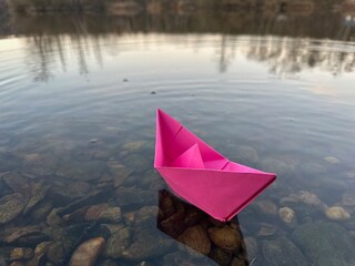 Paper boat floats on the water, origami