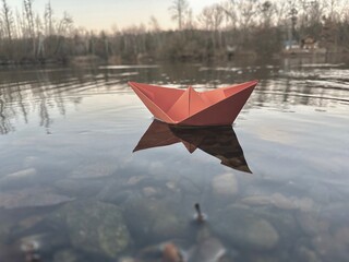 Paper boat floats on the water, origami