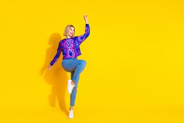 Full body photo of attractive young woman dance have fun dressed stylish colorful blue clothes isolated on yellow color background