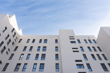 low-angle view of modern apartment building against a clear blue sky