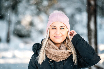 Portrait of beautiful smiled woman outdoors in snowed forest copy space. Good looking woman wearing...