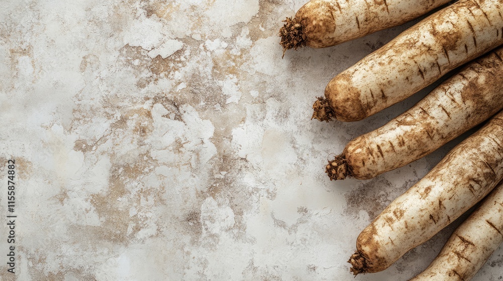 Poster fresh cassava tubers arranged on a textured surface with empty space for text showcasing the rustic 
