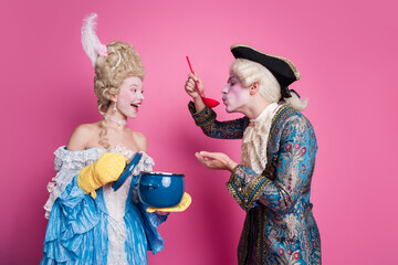 A delightful, costumed couple in a whimsical, pink-themed setting, with a nod to historical...