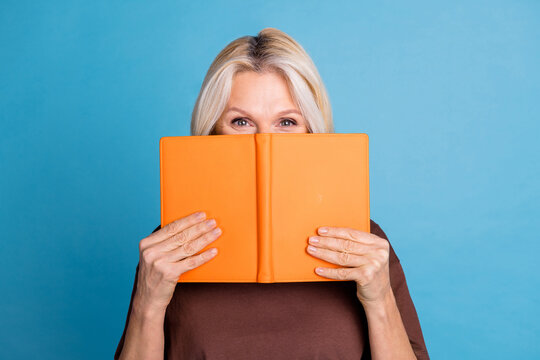 Photo of adorable charming funny woman wear trendy brown clothes hold book isolated on blue color background