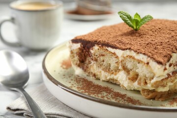 Piece of tasty tiramisu on white table, closeup