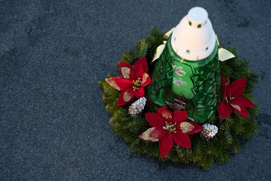 Christmas decoration on a grave: a wreath and a candle in the shape of a Christmas tree.