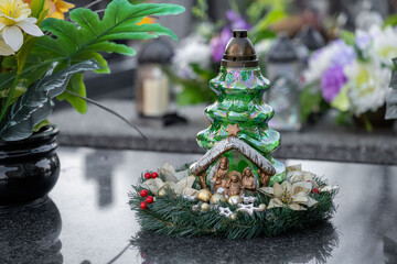 Christmas decoration on a grave: a wreath and a candle in the shape of a Christmas tree.