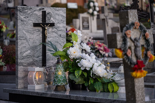 Elegant white flowers and candles on a marble tomb.
