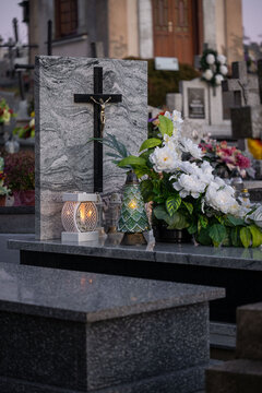 Elegant white flowers and candles on a marble tomb.