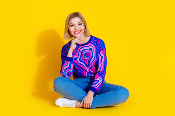 Full body photo of attractive young girl sit floor minded dressed colorful stylish blue clothes isolated on yellow color background