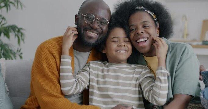 Slow motion portrait of happy African American family mother father son having fun laughing looking at camera at home. People and happiness concept.