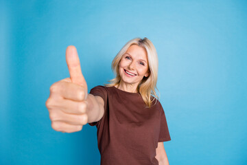 Fototapeta premium Photo of cheerful lovely nice woman wear stylish clothes demonstrate thumb up symbol isolated on blue color background