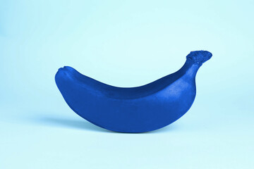 One blue banana on light blue background