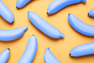 Light blue bananas on pale orange background, flat lay