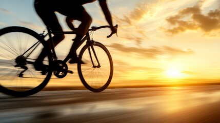 Obraz premium A man riding a bike on a road at sunset