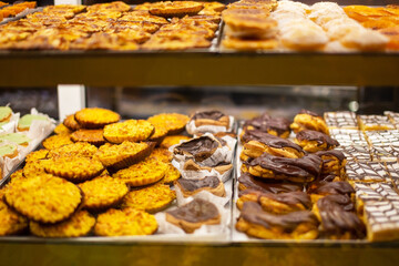 Assortment of different cookies in a shop window. Selective focus.
