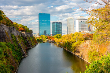Obraz premium East Outer moat of Osaka castle with Business Park skyscrapers in autumn, Osaka, Japan