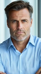 Fototapeta premium A man in a blue shirt with his arms crossed