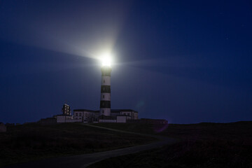 Breathtaking Night View of Phare du Cr&eacute;ac'h Lighthouse Illuminating the Starry Sky on Ouessant Island, Brittany, France