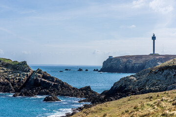 Scenic Coastal View of Rugged Cliffs and Lighthouse in Brittany, France with Clear Blue Skies and...