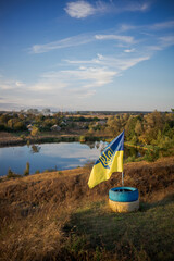 Ukrainian flag with trident near peaceful lake