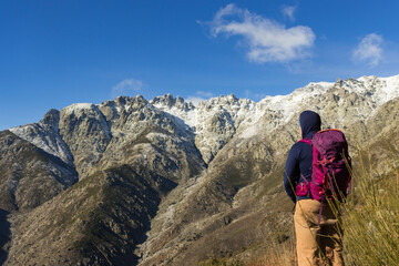 Fototapeta premium Mountaineer looking at the Sierra de Gredos with snow, southern part, travel ads and postcards, unusual views of the area.