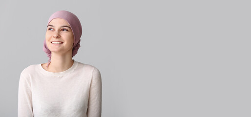 Optimistic woman after chemotherapy on light background