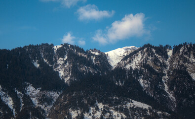 Majestic Mountain Landscape with Snow-Capped Peaks and Forest, Blue Sky