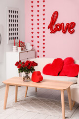 Interior of festive living room with different decorations, gift box and roses bouquet for Valentine's Day celebration