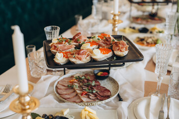Catering service presenting delicious canapes and sliced meat during wedding reception
