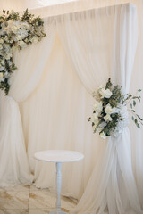 Elegant white wedding decorations framing a small table