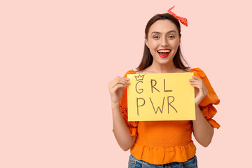 Beautiful young pin-up woman holding paper with text GRL PWR on pink background