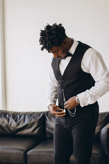 Elegant groom adjusting pocket watch getting ready for wedding