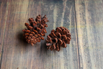 a bunch of dried pine cones on an abstract patterned wooden board