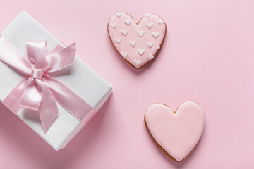 Tasty heart shaped cookies with gift box on pink background. Valentine's Day celebration